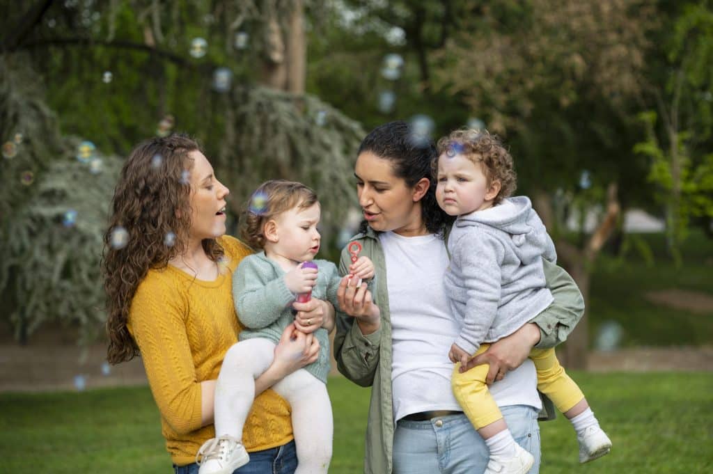 2 mamans avec leurs enfants dans les bras